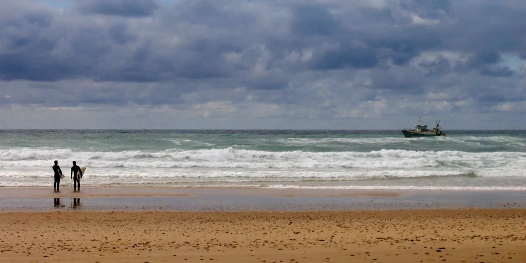 Deux surfeurs face aux vagues sur la plage de Lacanau-Océan